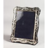 A SERPENTINE EDGE SILVER PHOTOGRAPH FRAME. 7ins x 6ins.