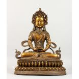 A LARGE GILT BRONZE FIGURE OF A SEATED DEITY, inlaid with semi-precious stones. 17.5ins high.