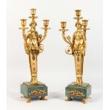 A PAIR OF EMPIRE STYLE GILT BRONZE FIGURAL CANDELABRA, mounted on green marble bases. 18ins high.