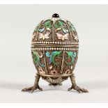 A GOOD RUSSIAN SILVER AND ENAMEL EGG in two halves, each with eight enamel panels and cabochon