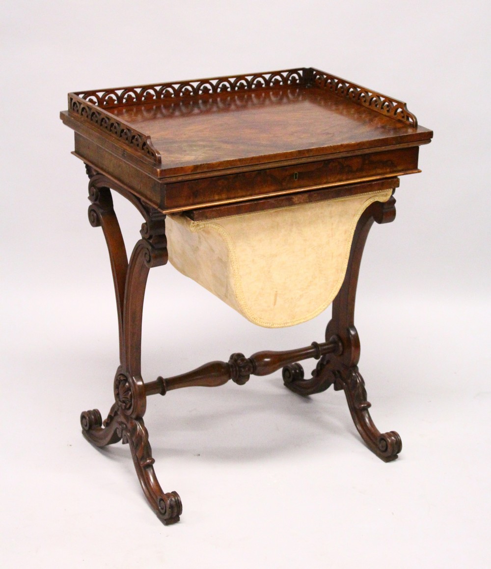 A VICTORIAN WALNUT WORK TABLE, with galleried top over a single drawer and work bag, on curving