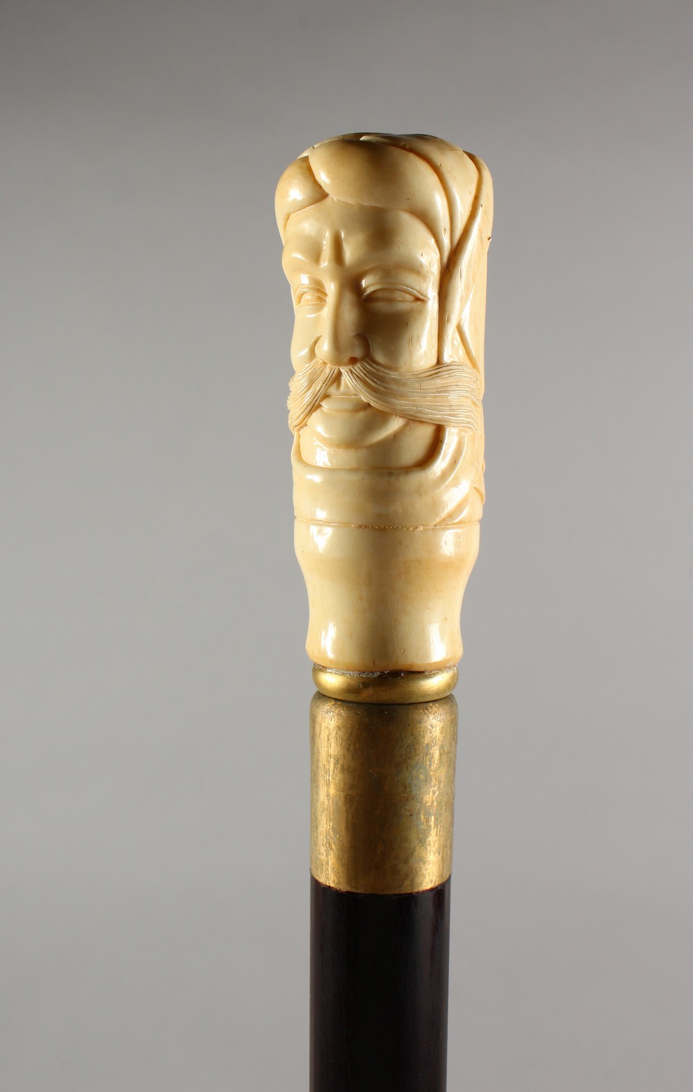 A BONE HANDLED WALKING STICK, carved as a bust of a man. 36ins long.