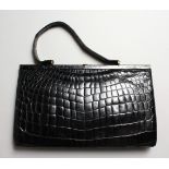 A LADIES BLACK CROCODILE LEATHER HANDBAG.