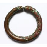 A ROMAN BRONZE BANGLE WITH ANIMAL HEADS