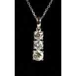 AN 18CT WHITE GOLD THREE STONE GRADUATED DIAMOND PENDANT NECKLACE.