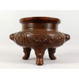 A LARGE BRONZE TWIN-HANDLED TRIPOD CENSER, the sides decorated with animals and birds in a