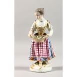 A 19TH CENTURY MEISSEN PORCELAIN FIGURE OF A YOUNG GIRL, carrying a basket of flowers. 5ins high.