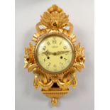 A CARVED GILTWOOD CARTEL WALL CLOCK. 20ins high.