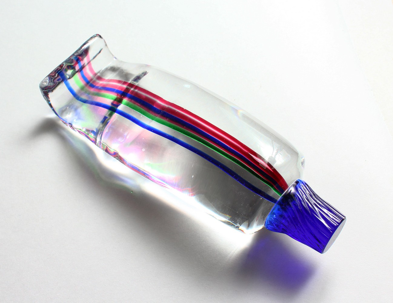 A MULTI-COLOURED STRIPED GLASS TOOTHPASTE TUBE. 8ins long.