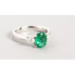 AN 18CT WHITE GOLD, EMERALD AND DIAMOND RING, the central oval emerald flanked by trillion cut