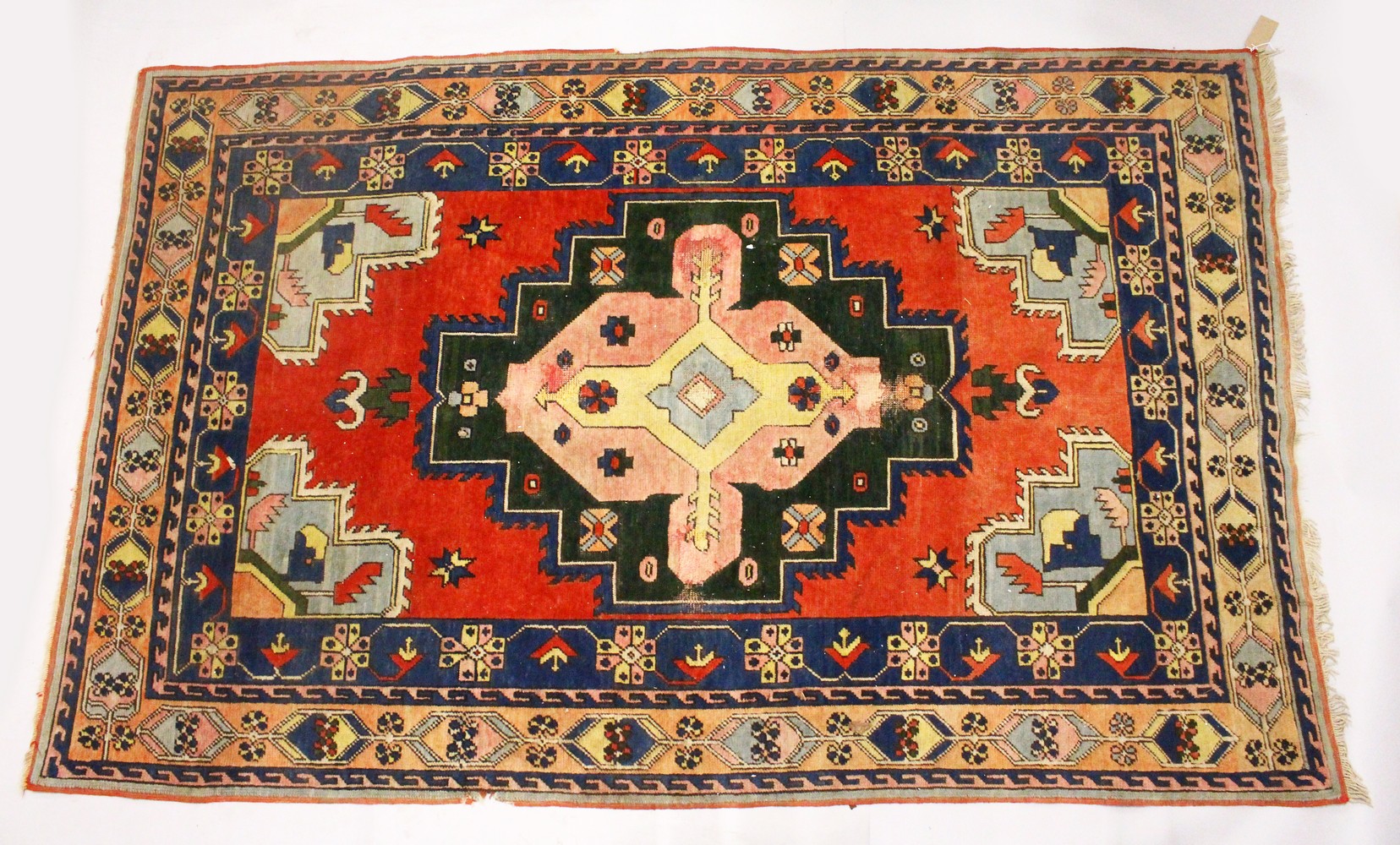 A PERSIAN RUG, 20TH CENTURY, bright red ground with large stylised design, within a similar double
