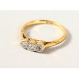 AN 18CT GOLD THREE STONE DIAMOND RING.