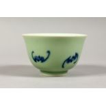 A SMALL CELADON GROUND TEA BOWL, painted with bats. 3.5ins diameter.