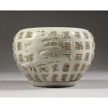 A WHITE GLAZED POTTERY BOWL, with moulded calligraphy decoration. 6.5ins diameter.