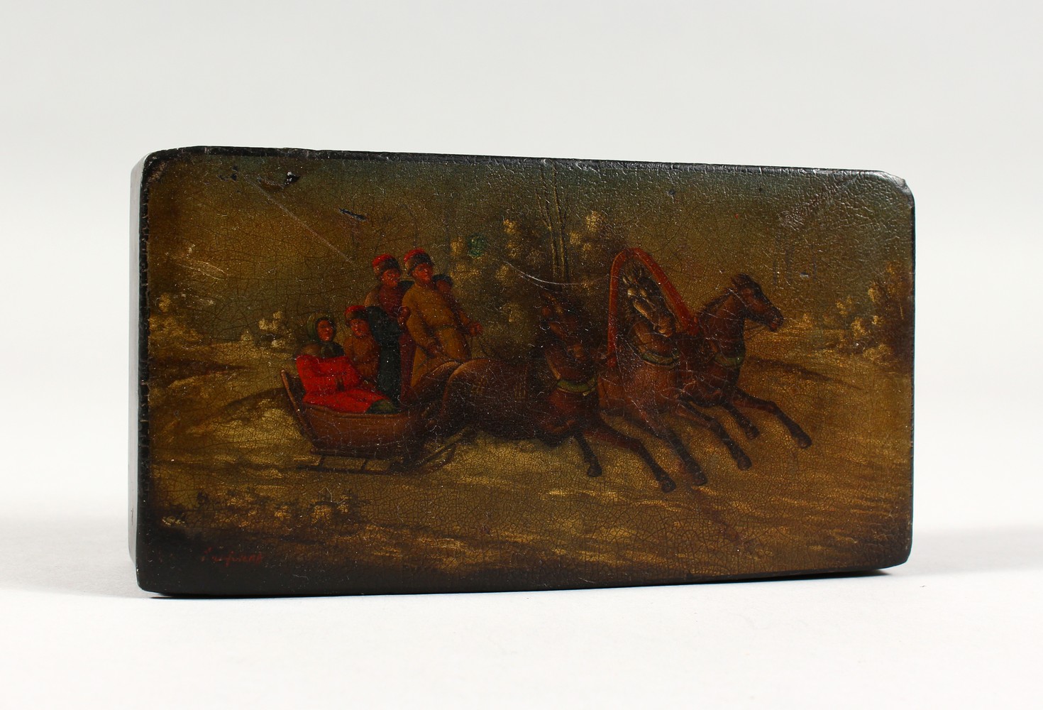 A RUSSIAN LACQUER RECTANGULAR BOX, painted with figures and horses pulling a sleigh. 6.75ins long.