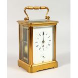 A BRASS CARRIAGE CLOCK, with white enamel dial, the movement striking on a gong. 6.5ins high.