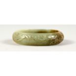 A PALE CARVED JADE BANGLE.