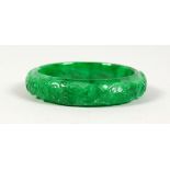 A CARVED APPLE GREEN JADE BANGLE. 3ins diameter.