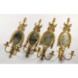 A SET OF FOUR BRASS CLASSICAL STYLE MIRROR BACK TWO BRANCH WALL SCONCES. 24.5ins high.