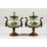 A SUPERB PAIR OF 19TH CENTURY SEVRES PORCELAIN URNS AND COVERS, pale blue ground, painted with