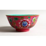 A CHINESE CIRCULAR BOWL, pink ground decorated with flowers. 6.5ins diameter.
