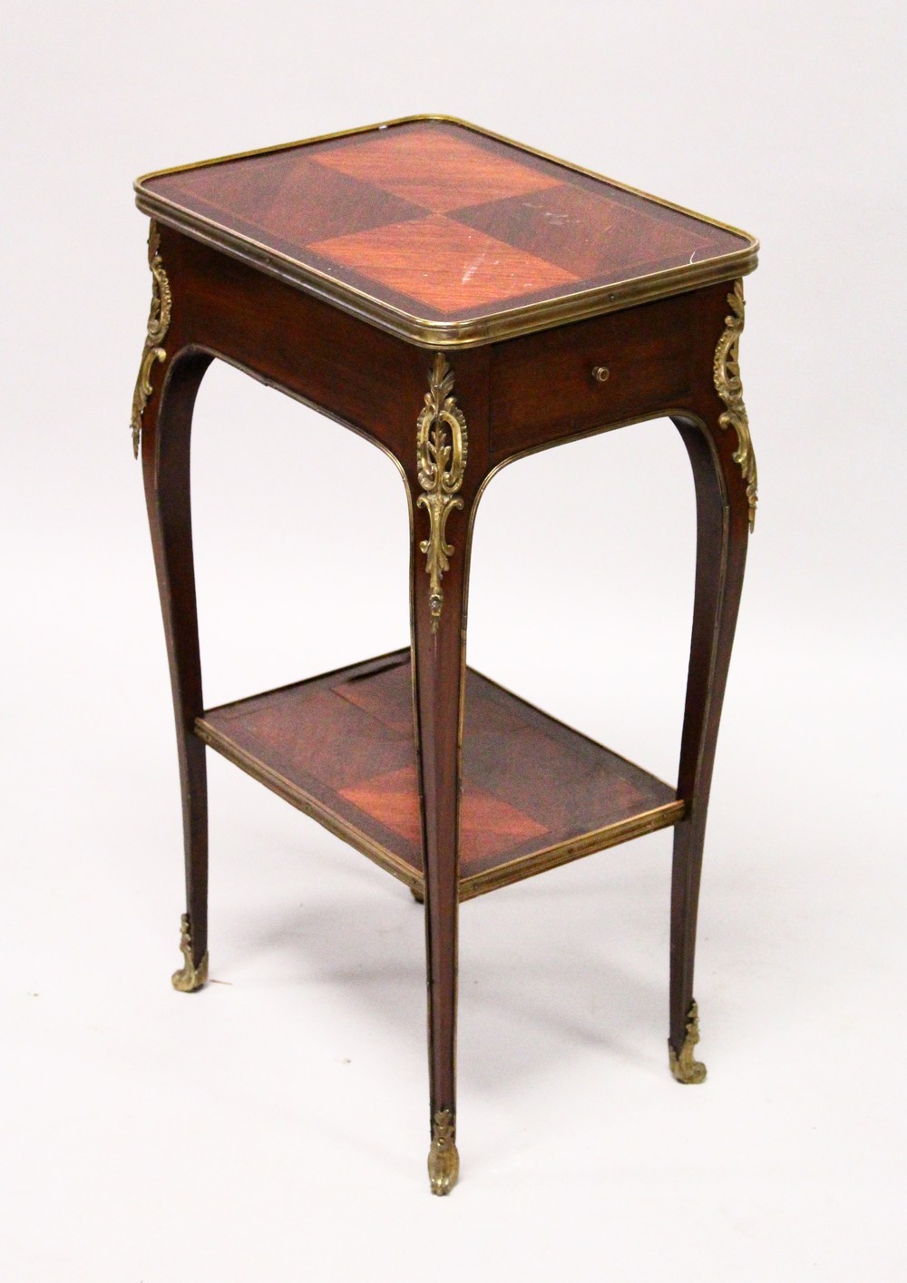 A SMALL LATE 19TH CENTURY FRENCH MAHOGANY AND ORMOLU TABLE, with a drawer to one end, on slender