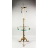 A BRASS FLOOR STANDING LAMP, with a galleried glass shelf, on a tripod base. 52ins high.