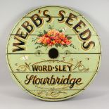 A LARGE CIRCULAR WOODEN BARREL LID, later decoratively painted "Webb's Seeds". 32ins diameter.