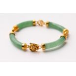 A JADE BRACELET, with four curving sections and gilt metal mounts. 7ins long.