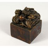 A SQUARE BRONZE SEAL, mounted with dragons. 3ins wide.