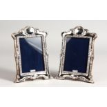 A PAIR OF VICTORIAN STYLE EMBOSSED SILVER PHOTOGRAPH FRAMES. 8ins x 6ins.