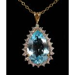 A 9CT GOLD BLUE TOPAZ AND DIAMOND PENDANT on chain.