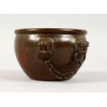 A CHINESE CIRCULAR BRONZE CENSER, with four mask handles linked by chains. 4.25ins diameter.