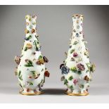 A GOOD PAIR OF MEISSEN FLOWER ENCRUSTED VASES, painted with butterflies. 12.5ins high. Cross