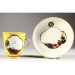 A SUPERB 18TH CENTURY MEISSEN CUP AND SAUCER, with yellow ground, the cup painted with two landscape