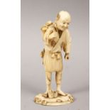 A GOOD JAPANESE MEIJI PERIOD CARVED IVORY OKIMONO OF A FISHERMAN, the man stood upon a stylized