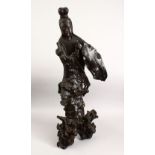 A GOOD 18TH CENTURY CARVED ROOT WOOD FIGURE OF GUANYIN, stood in a natural pose holding a vessel,