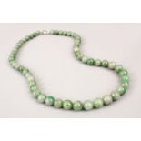 A GOOD CHINESE APPLE GREEN CARVED JADE NECKLACE, approx 52cm.