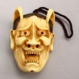 A JAPANESE MEIJI PERIOD CARVED IVORY NETUSKE OF A HANNYA MASK - SIGNED, the Netsuke depicting a