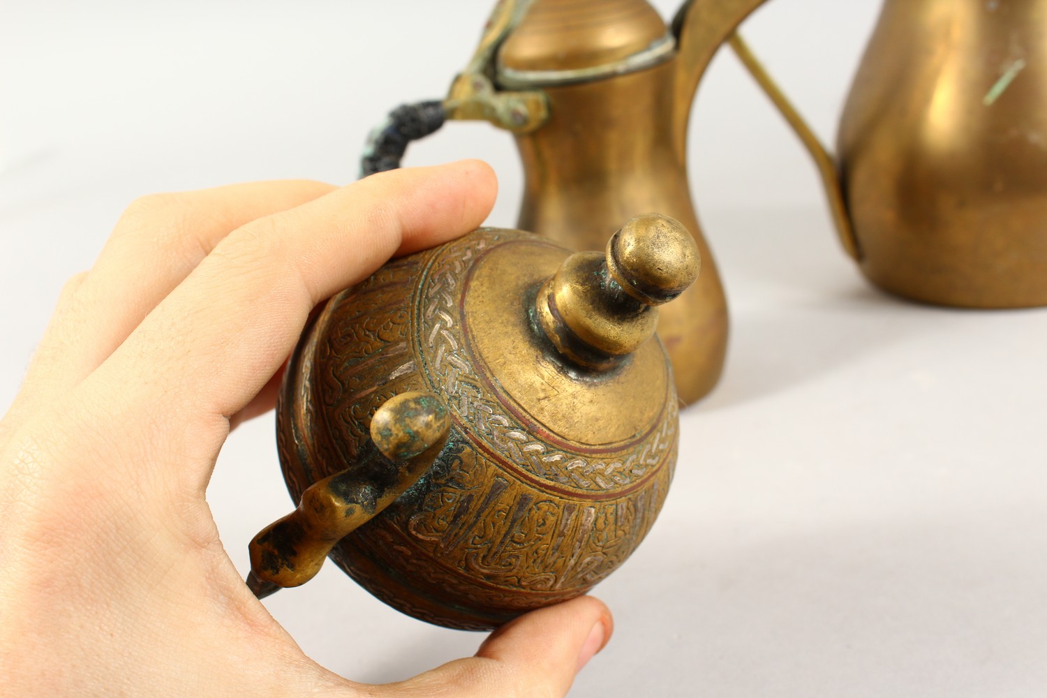 A SET OF THREE ANTIQUE ARABIC BRASS COFFEE POTS SIGNED DALLAH & AN ISLAMIC SILVER INLAID LID, coffee - Image 12 of 15