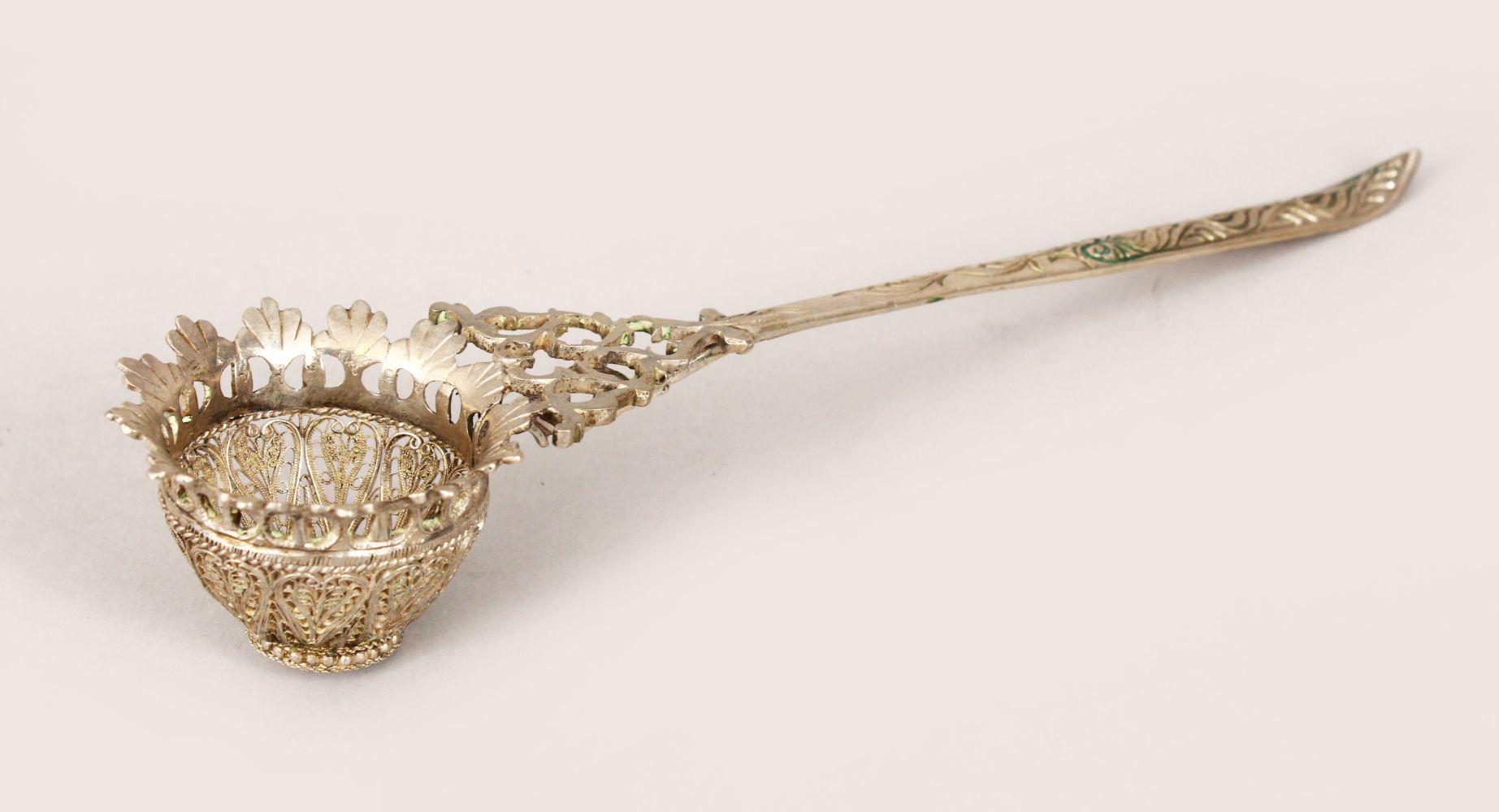 A 19TH CENTURY INDIAN SILVER FILIGREE TEA STRAINER, 17cm long.