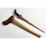 A GOOD 19TH CENTURY INDONESIAN KRIS DAGGER, with a chased brass scabbard, and a carved hardwood