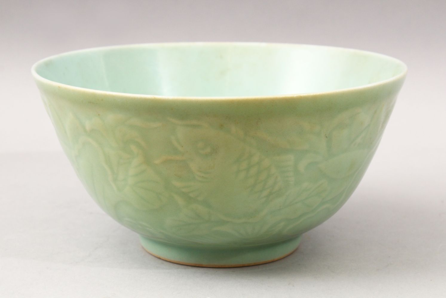 A GOOD 19TH CENTURY CHINESE MOULDED CELADON FISH BOWL, the bowl with moulded decoration depicting