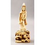 A GOOD JAPANESE MEIJI PERIOD CARVED IVORY OKIMONO OF KWANNON, the goddess stood upon a rock form