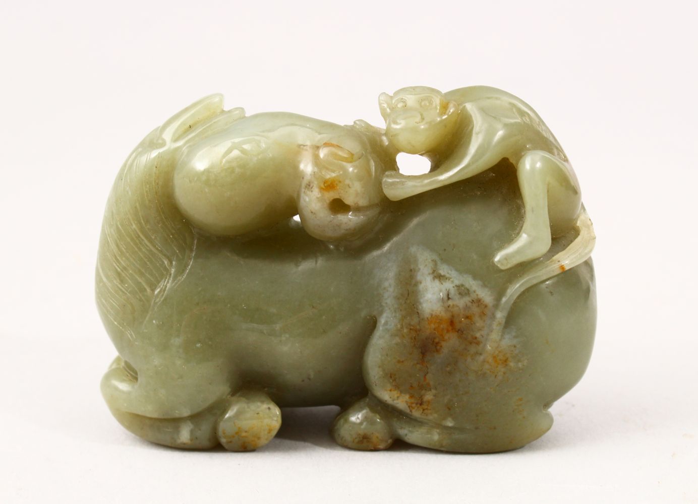 A GOOD 19TH CENTURY CHINESE CARVED JADE FIGURE OF A SEATED HORSE, the horse with a monkey climing