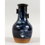 A GOOD 20TH CENTURY JAPANESE STUDIO POTTERY VASE OF FLORA, the vase with twin moulded handles,