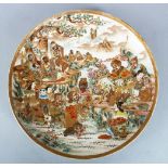 A JAPANESE MEIJI PERIOD SATSUMA DISH, the body of the dish profusely decorated with immortals in a