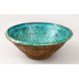 AN ISLAMIC POSSIBLY KASHAN GLAZED TURQUOISE POTTERY BOWL, the interior with incised decoration, 9.