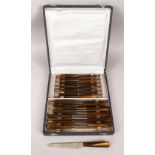 A 19TH / 20TH CENTURY BOXED SET OF TWENTY FOUR RHINO HORN HANDLED KNIVES AND BOX, 24cm long each,