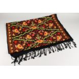 A CREWEL WORK STYLE EMBROIDERED SHAWL, black ground with floral decoration. 186cms x 70cms.